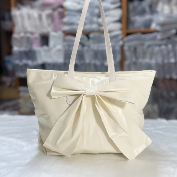 Large-capacity bow tote bag made of PU leather, fashionable design for daily use in white.