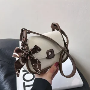 “Cute mini shoulder bag for women made of PU leather with button and zipper closure for daily use in brown.”