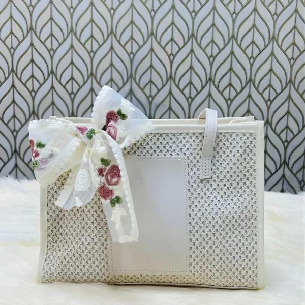 “Handwoven straw shoulder bag with polyester lining, large capacity for beach and travel use in off white.”