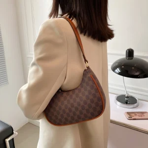 Imported ladies PU leather underarm handbag with zipper closure for daily use in brown outfit