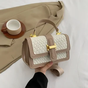 Luxury shoulder handbag made of PU leather with woven texture and gold hardware for casual fashion use in white.