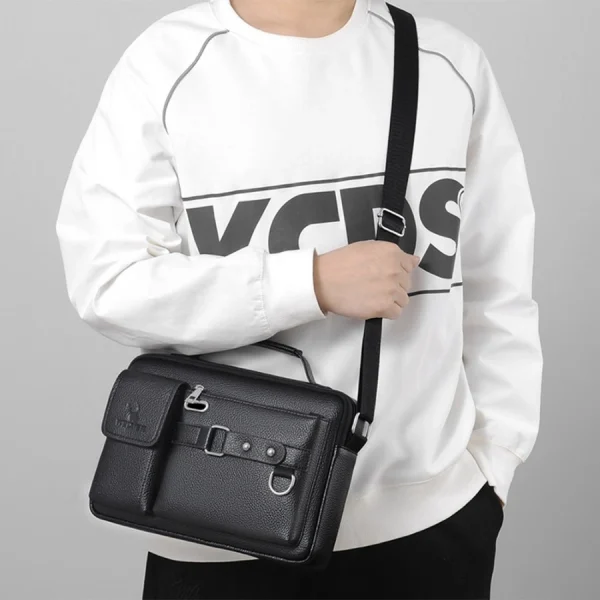“Men's leather shoulder bag made of PU leather with multi-pocket design for business and travel use in black outfit.”