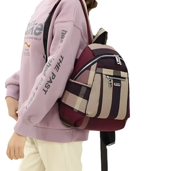 “Waterproof nylon casual backpack for women with durable lightweight design for daily use in red outfit.”