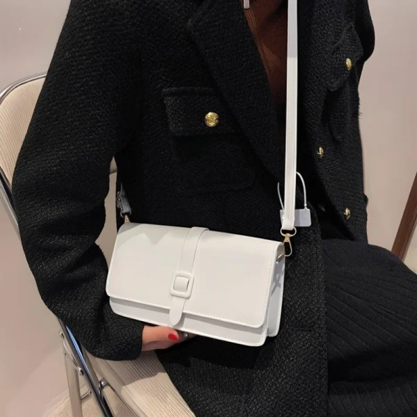 White faux leather crossbody shoulder bag with buckle strap for casual everyday use outfit