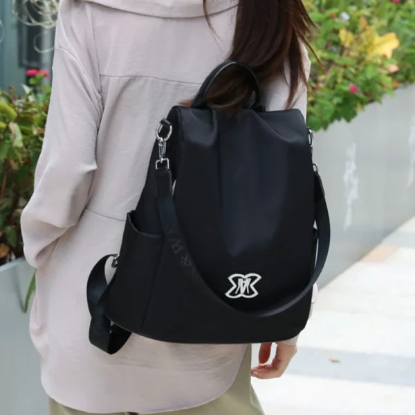 “Anti-theft women’s backpack and crossbody bag made of lightweight Oxford cloth for multi-purpose outdoor use in black outfit.”