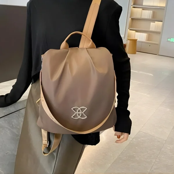 “Anti-theft women’s backpack and crossbody bag made of lightweight Oxford cloth for multi-purpose outdoor use in brown outfit.”